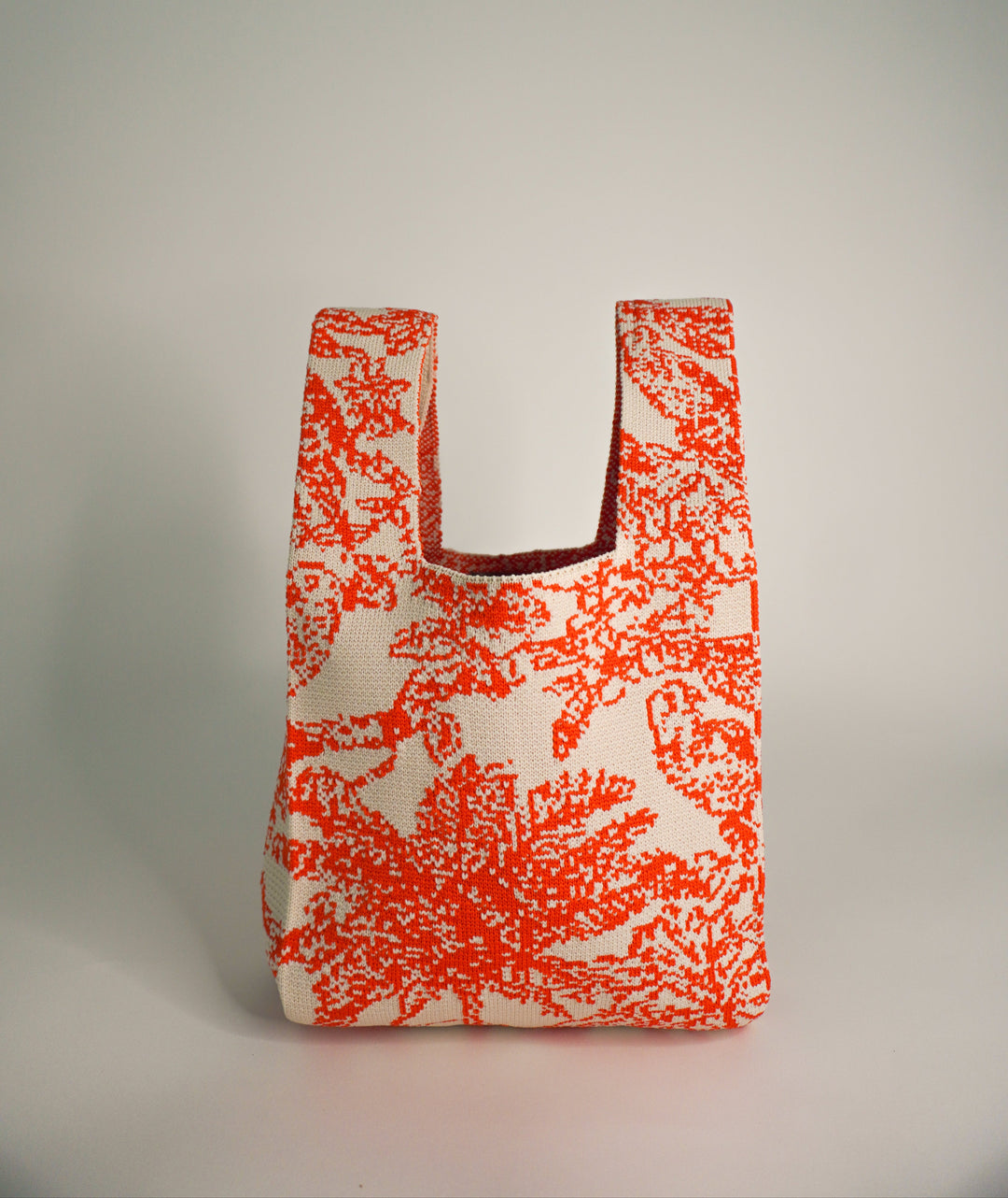 Orange and cream patterned tote handbag with wide body and two short handles