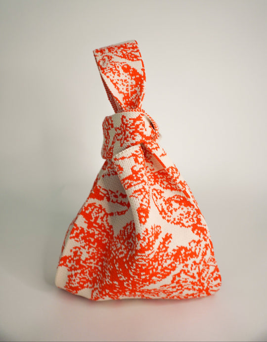 Palm Beach orange patterned handbag with knotted top and woven texture pouch
