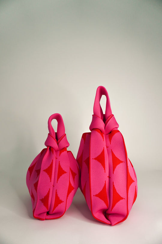 Pink Portobello handbags, side view of two with knotted drawstring tops