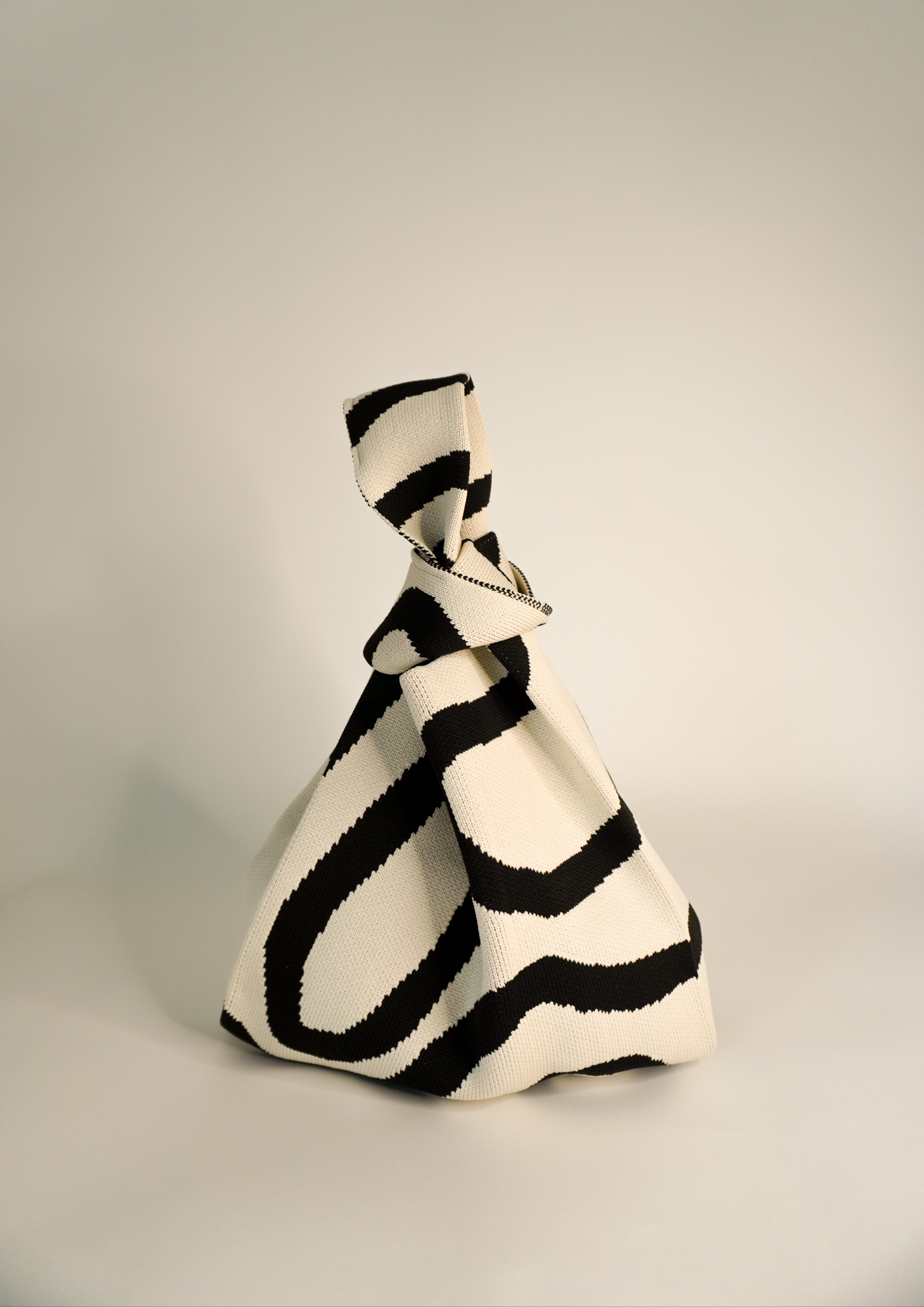 Meander Black handbag with bold black-and-cream striped print and twisted handle
