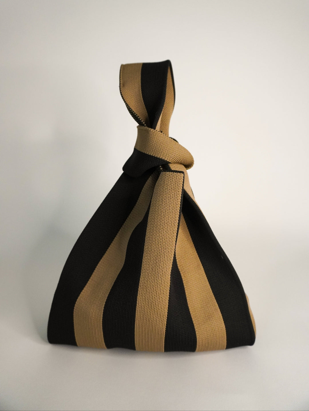 The Original Brown Handbag con diseño de rayas negro y marrón, asa trenzada y cierre anudado