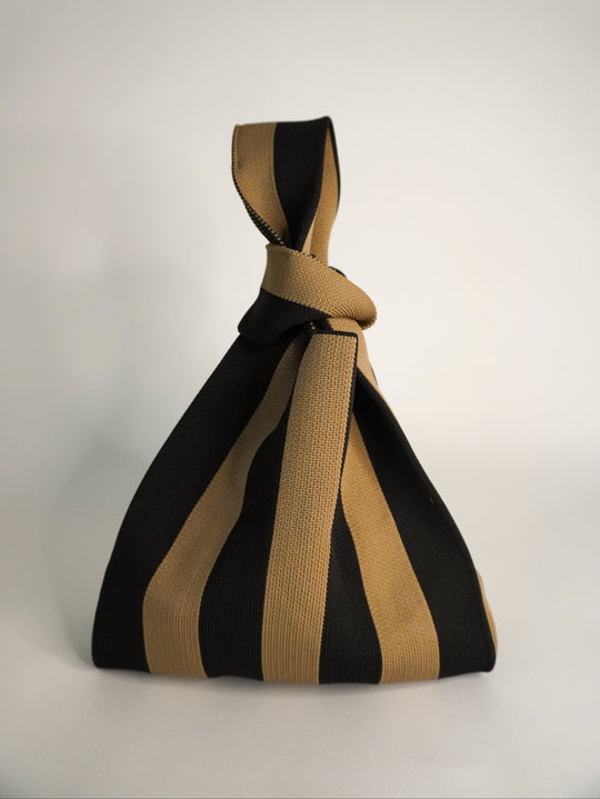 The Original Brown Handbag con diseño de rayas negro y marrón, asa trenzada y cierre anudado