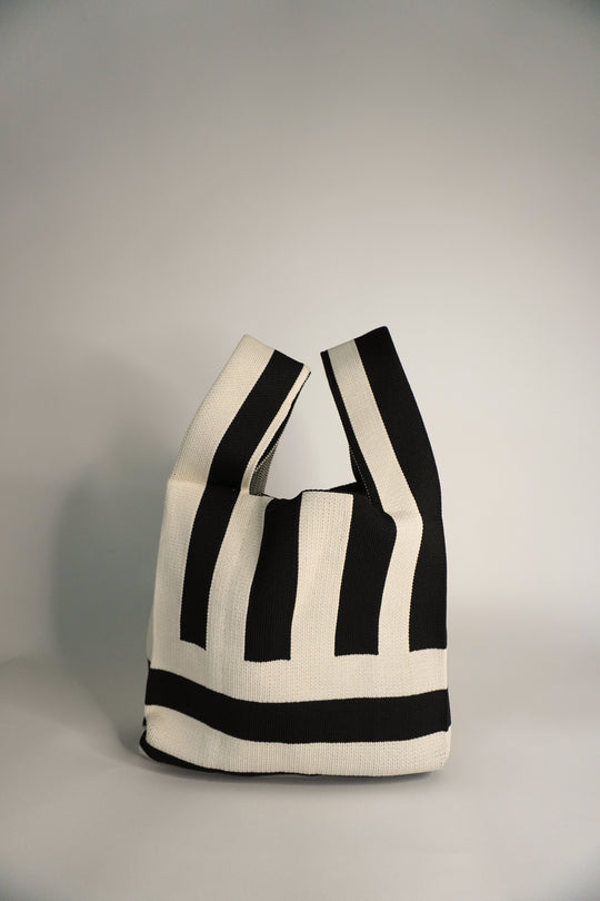 The Original² striped drawstring handbag in black and cream, side profile