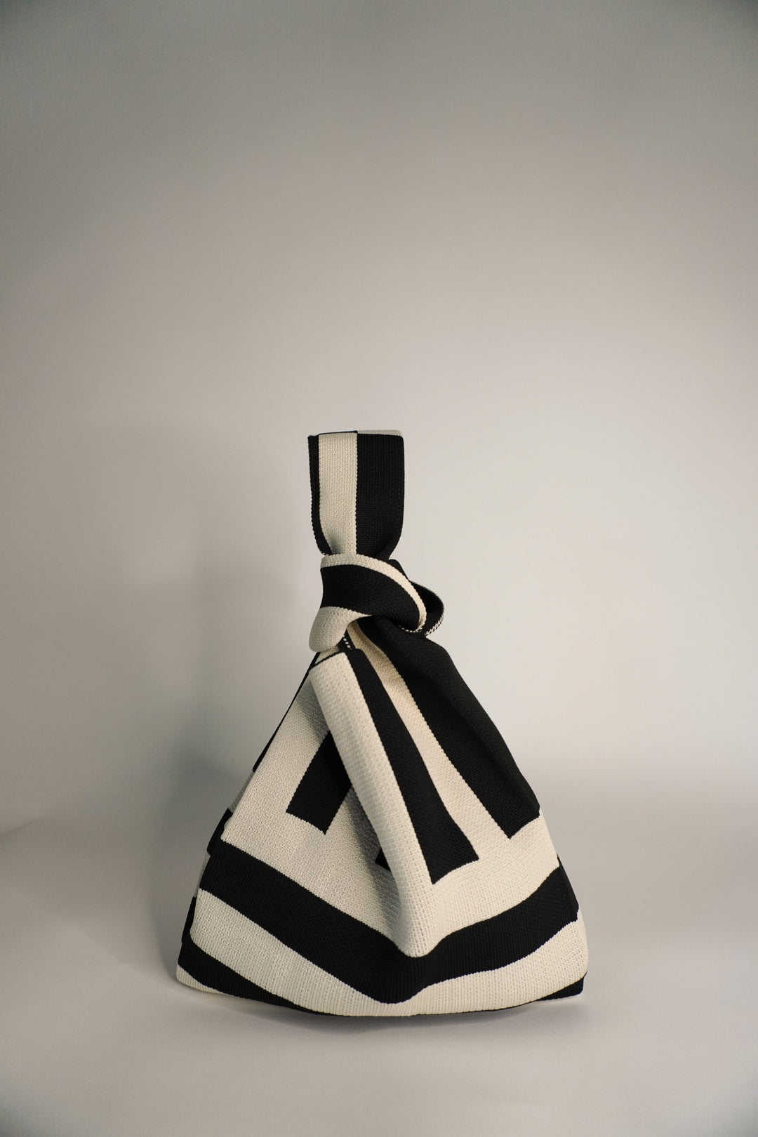 The Original² black-and-cream striped drawstring handbag, front view