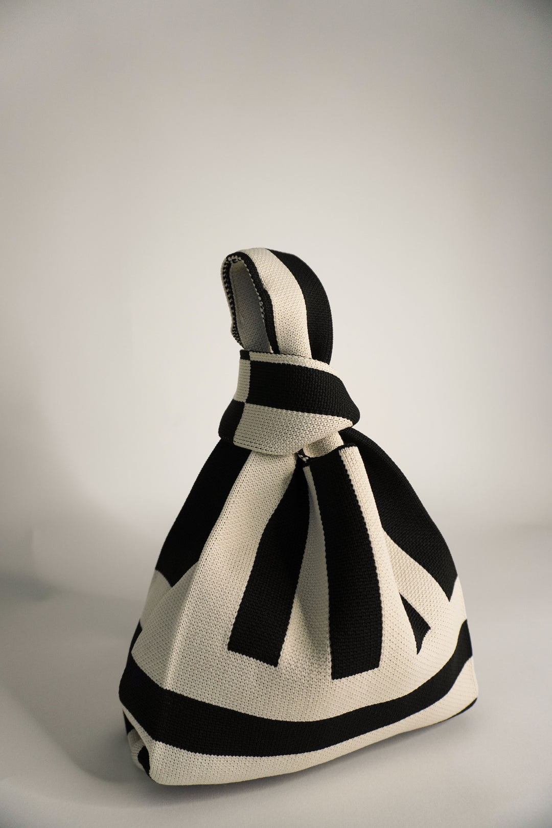 The Original² black and cream striped drawstring handbag with bow tie detail
