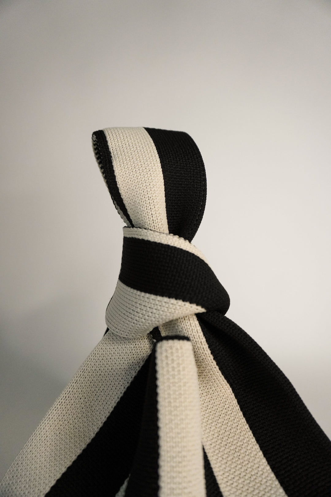 Close view of The Original² striped drawstring handbag top with tied strap