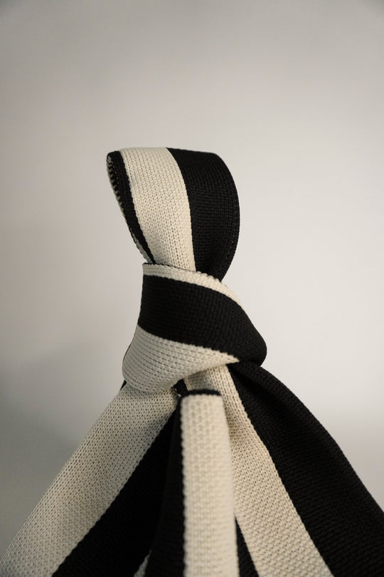 Close view of The Original² striped drawstring handbag top with tied strap