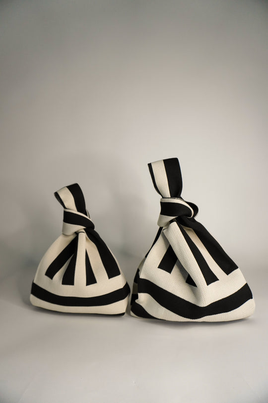 Two The Original² black-and-cream striped drawstring handbags, side view