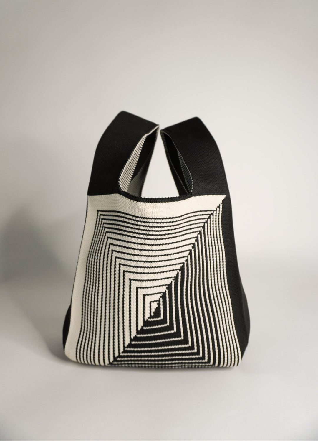 Labyrinth striped tote-style pouch in black and cream, open with drawstring.