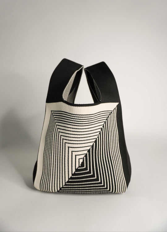 Labyrinth striped tote-style pouch in black and cream, open with drawstring.