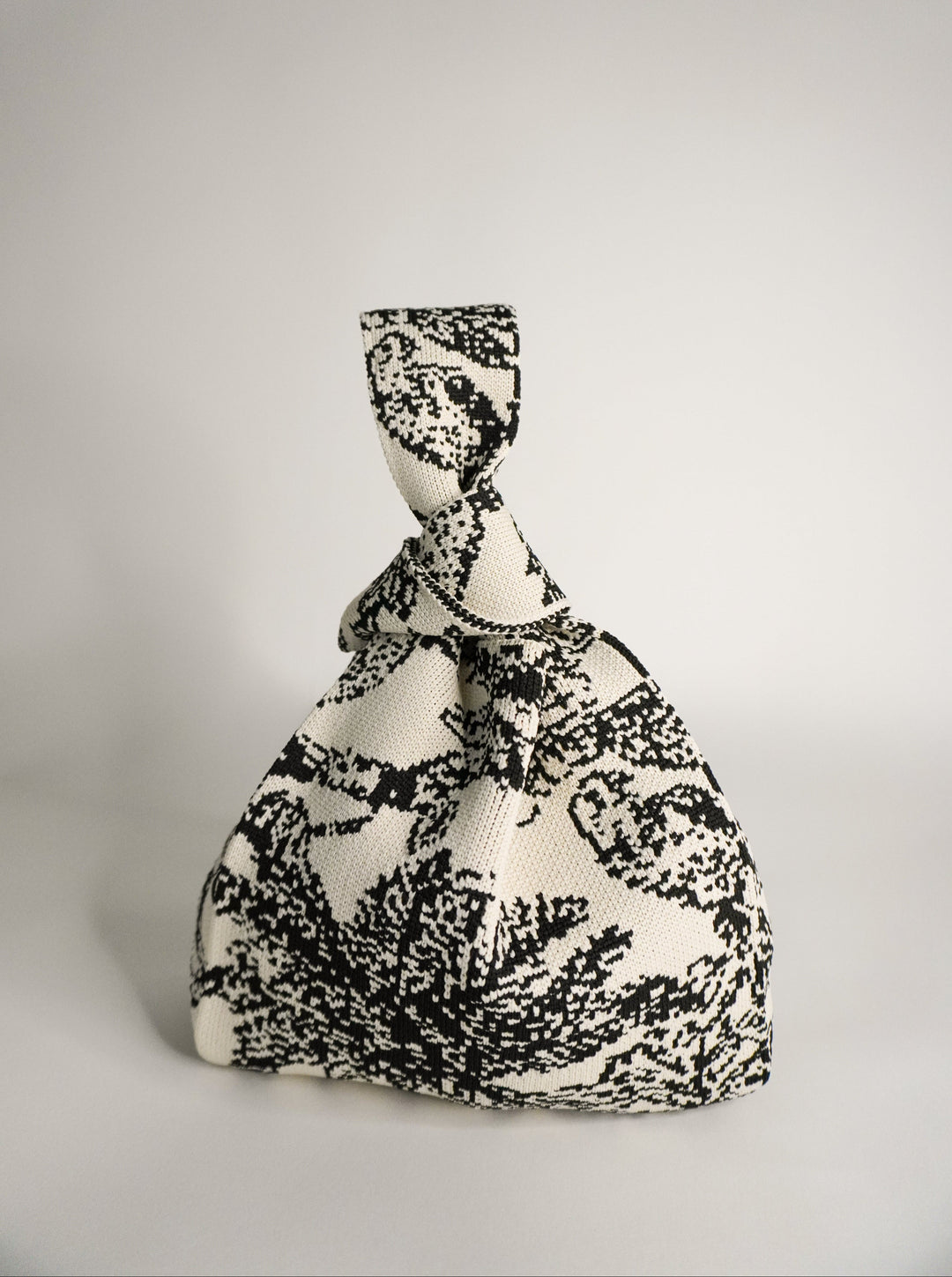 Palm Beach black handbag in monochrome woven pattern, tied drawstring top