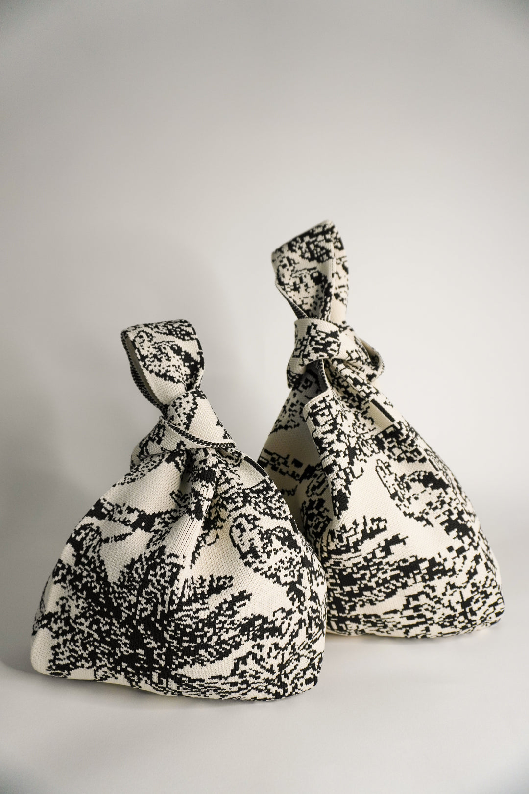 Palm Beach black handbag, pouch shape with knotted handles and black/white woven abstract print