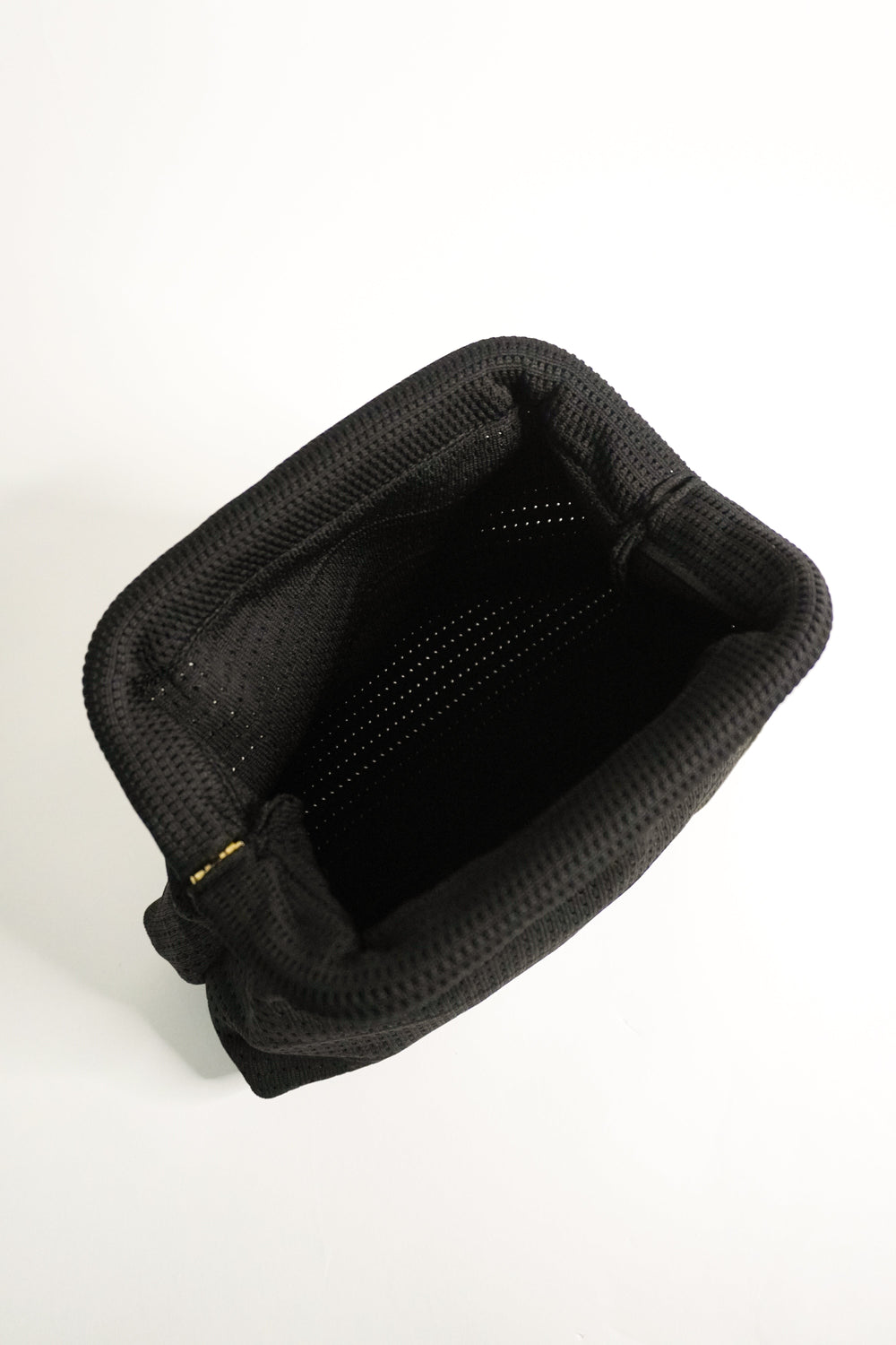 Black interior of woven clutch with top opening and fabric lining
