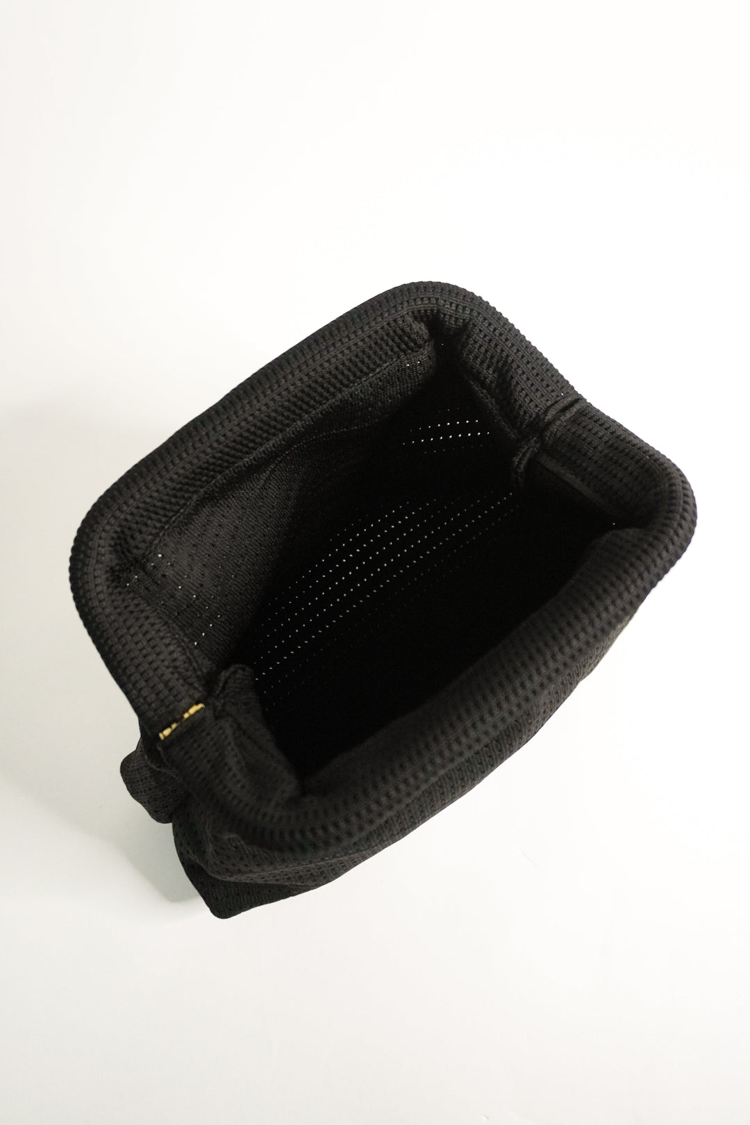 Black interior of woven clutch with top opening and fabric lining