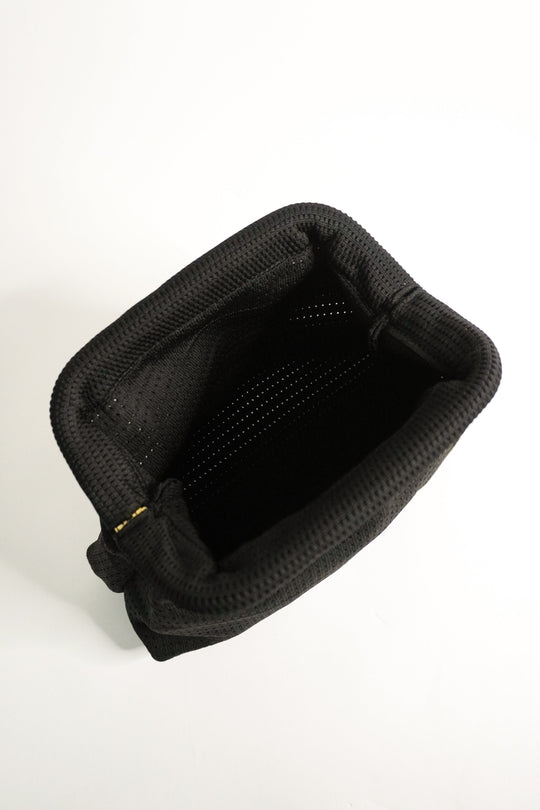 Black interior of woven clutch with top opening and fabric lining