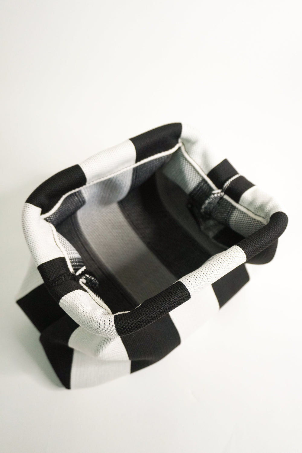Gestreifte Clutch-Tasche mit Innenfutter, schwarze und weiße Streifen, offen