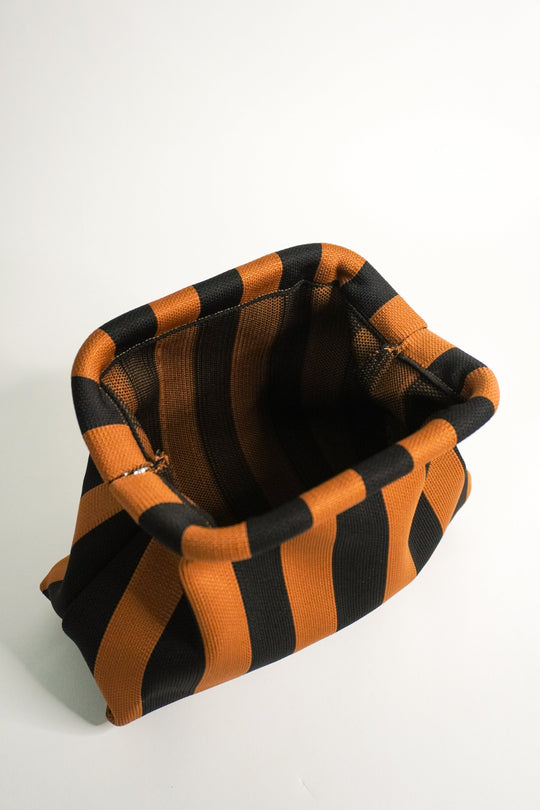 Brown-and-black striped clutch bag interior view, folded top opening