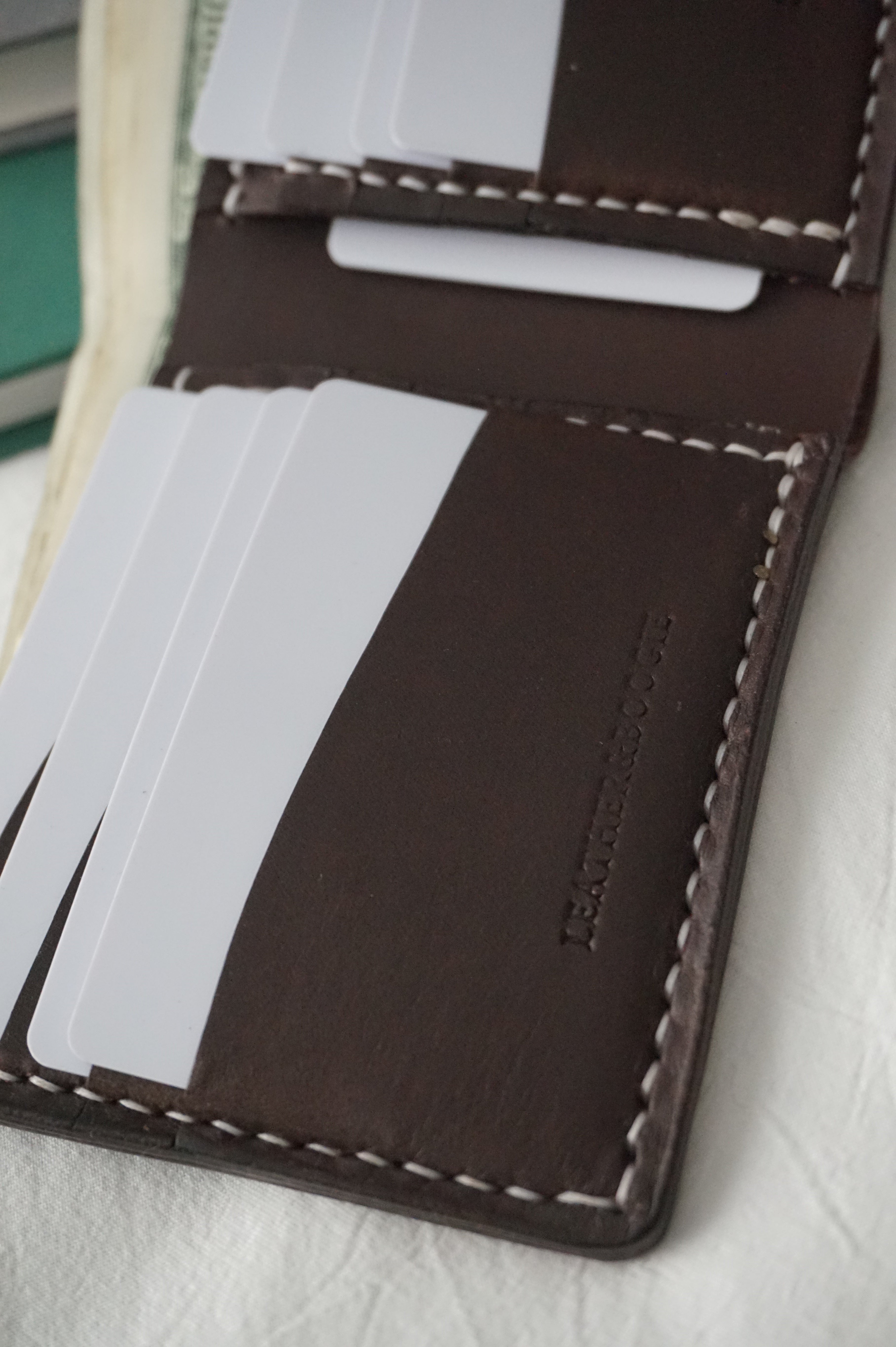 11-pocket bi-fold wallet with card slots and stitched edge, dark brown leather