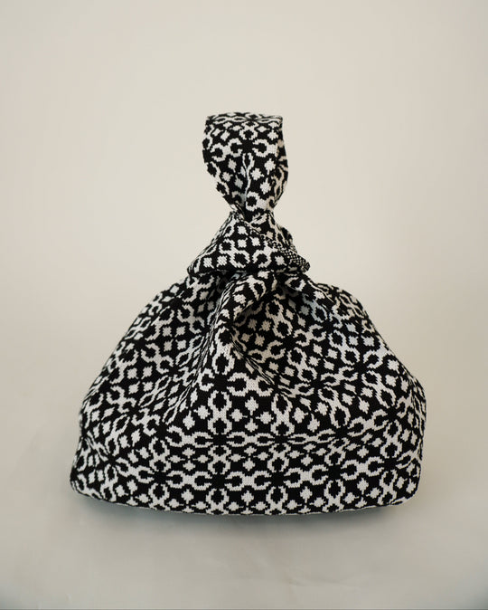 Black Solitaire handbag with bow-top drawstring and black-and-white geometric print