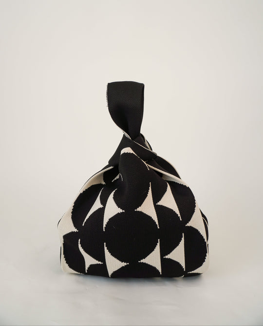 Black Portobello handbag with black drawstring pouch and bold black-and-white print