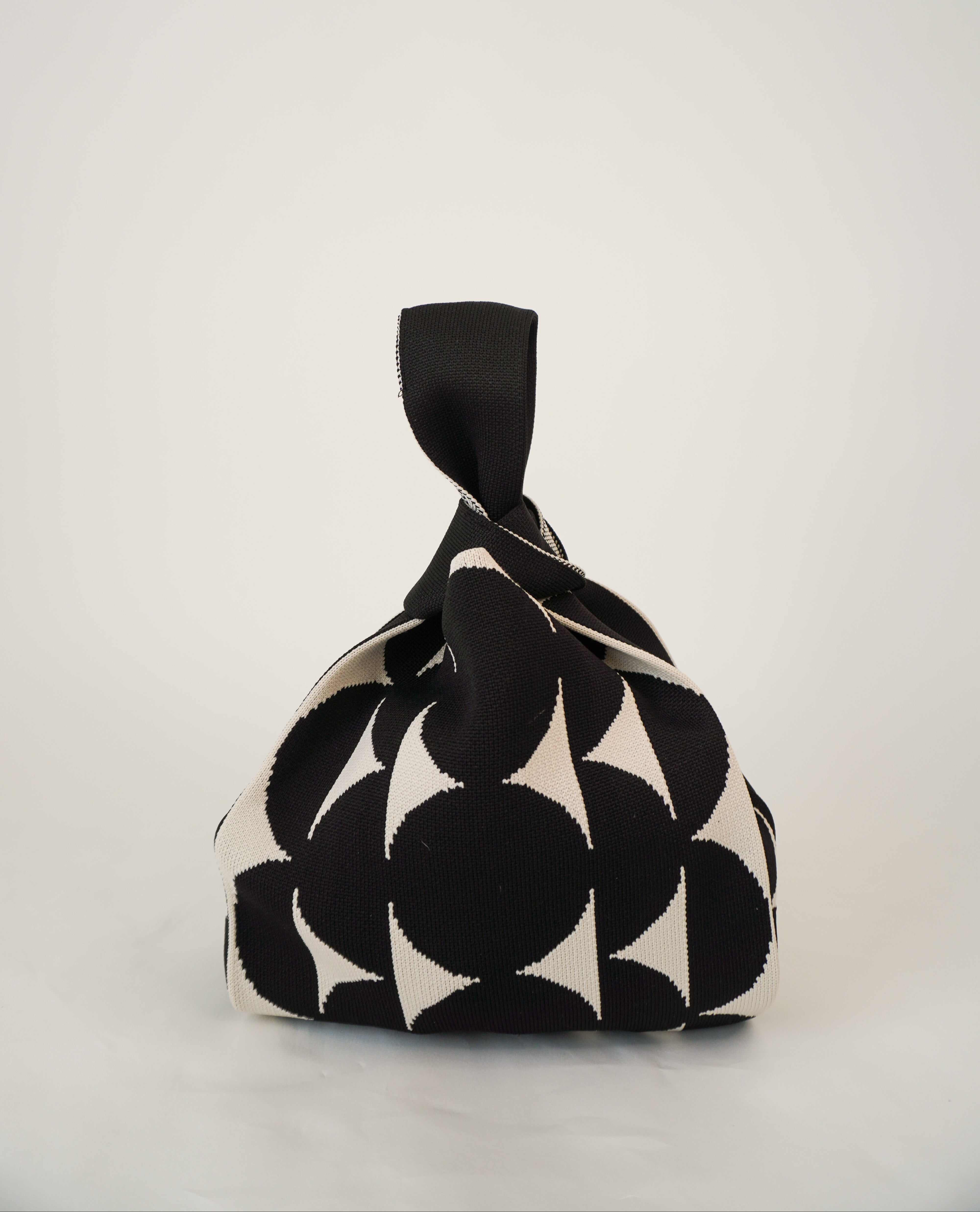 Black Portobello handbag with black drawstring pouch and bold black-and-white print