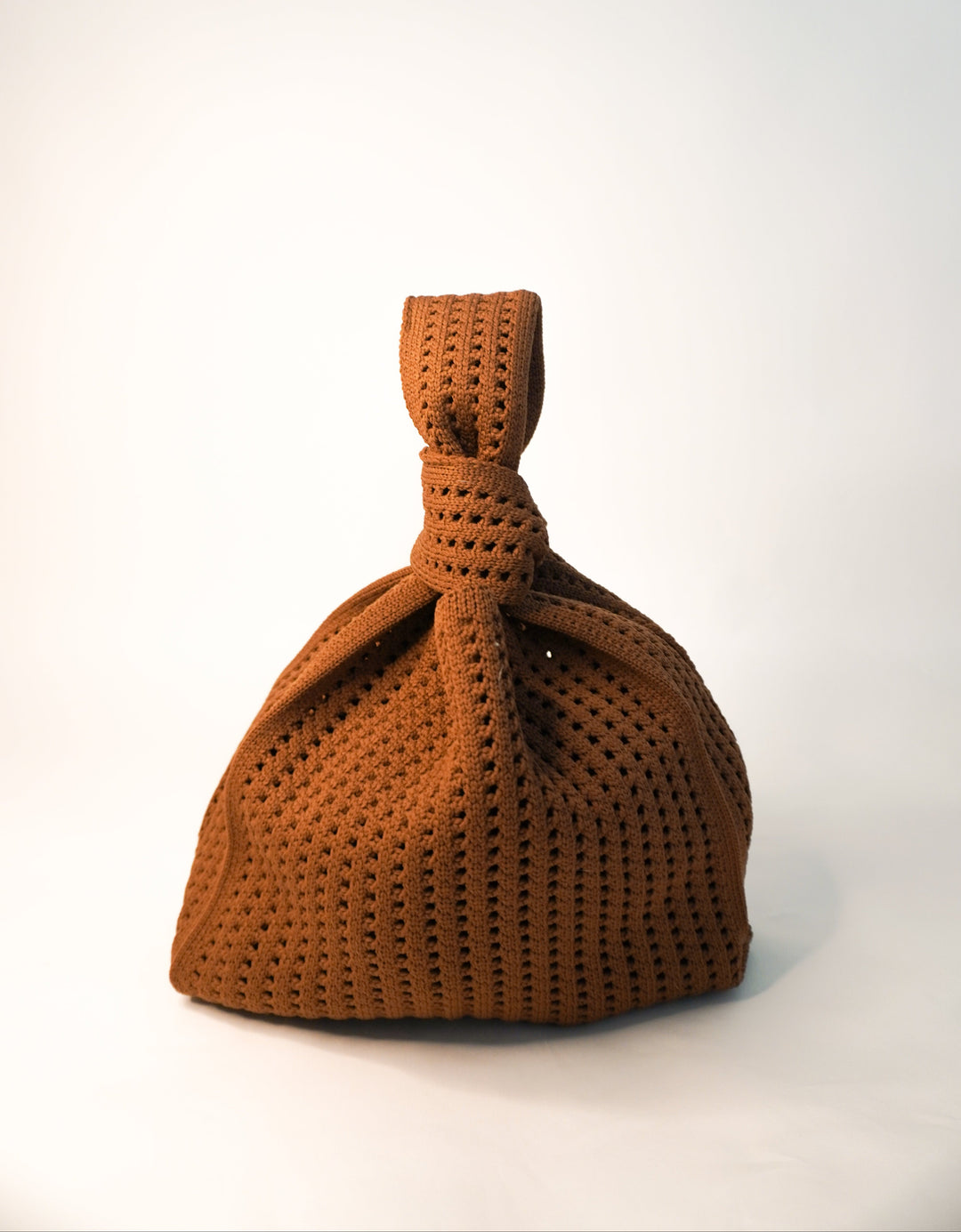 Brown crochet drawstring handbag with gathered top and braided-look tie