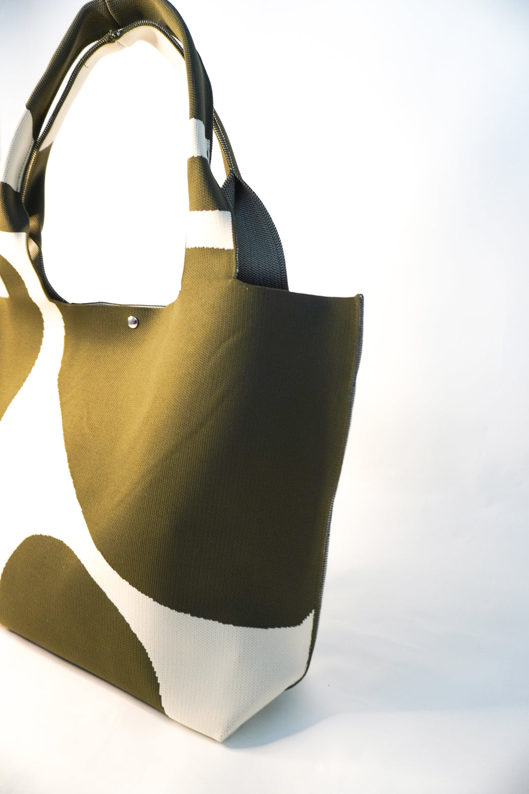 MOOdy Green Signature Tote angled view, wide base and short handles, green with white patches