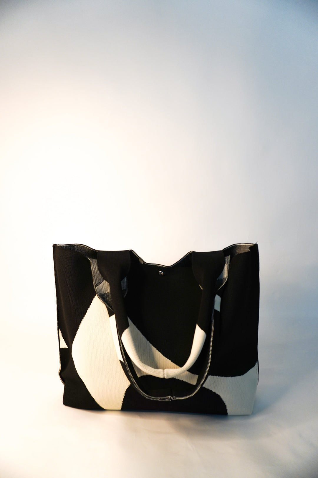 MOOdy tote con asa tipo bolsa y cierre con cordón, patrón negro y paneles blancos