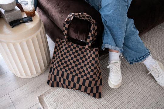 Checkered skinny tote with rounded top handles, open top, and brown-and-black square pattern.