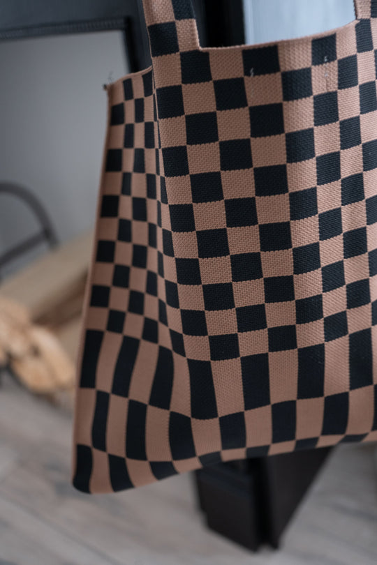 Side view of checkered skinny tote bag with brown-and-black squares and vertical bottom stripes.