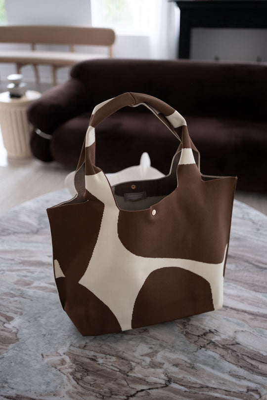 Brown tote with cream abstract pattern, open top lining visible, front snap detail