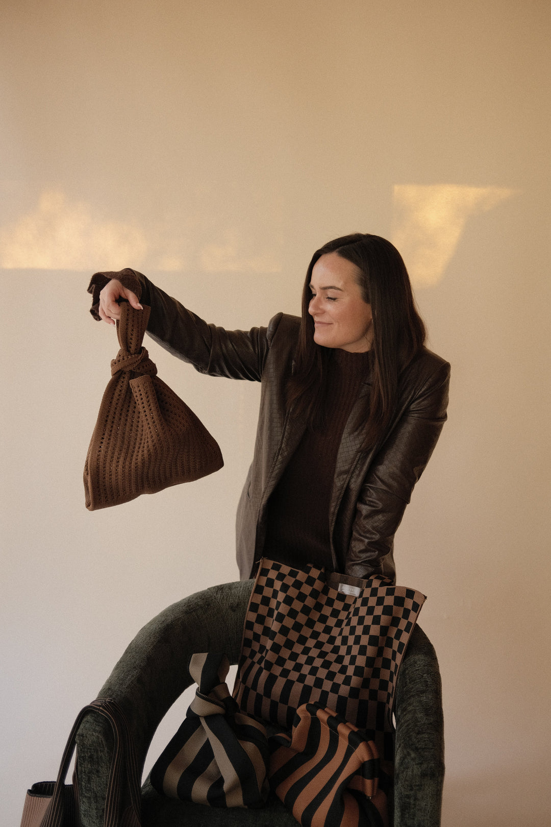 Brown crochet drawstring handbag with short handle loops, hanging open