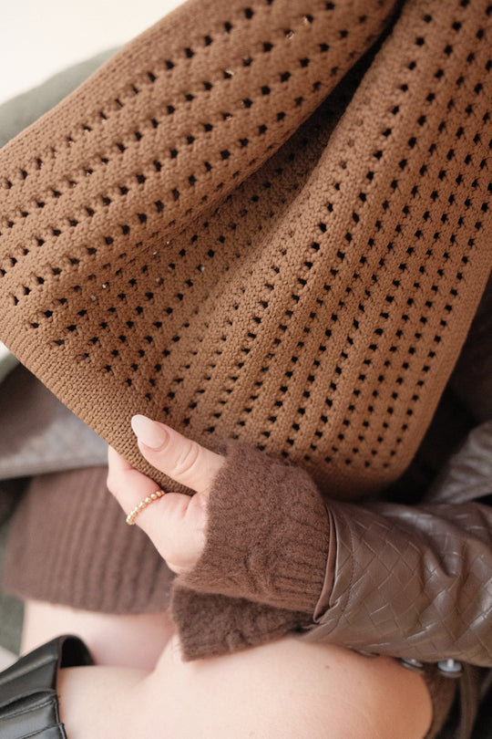 Close-up of brown crochet texture with small square openings and side pleats