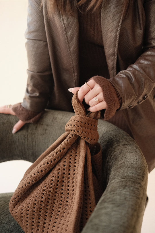 Brown crochet drawstring handbag detail with knot-style top and small openwork pattern