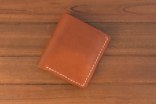 ID bi-fold wallet in brown leather with white stitching, closed front view