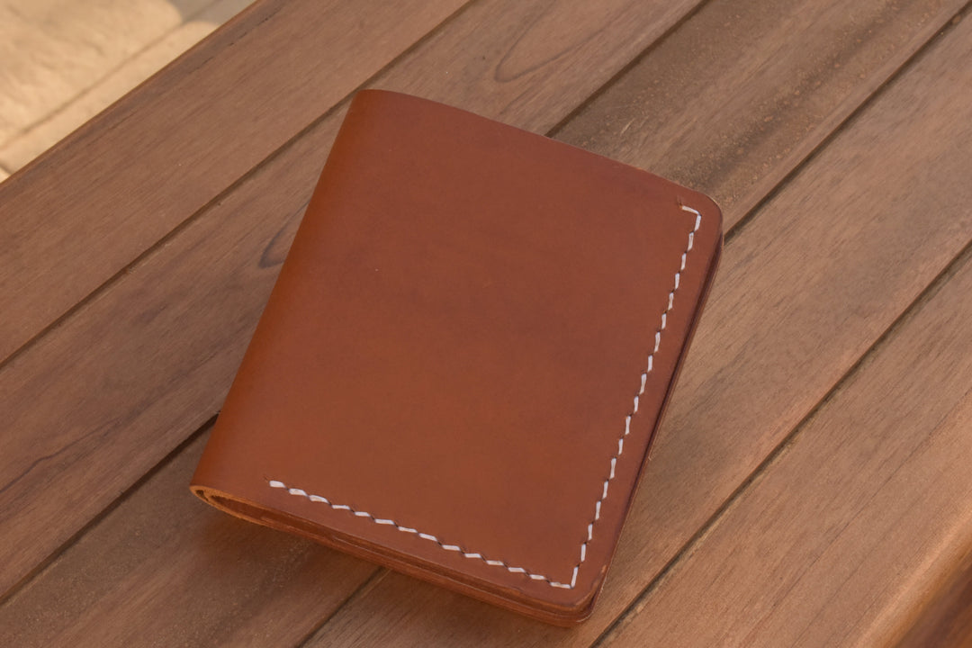 Brown ID bi-fold wallet with white edge stitching, compact folded design