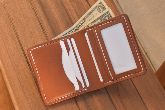 Open ID bi-fold wallet with cash in card slots and ID window, brown leather