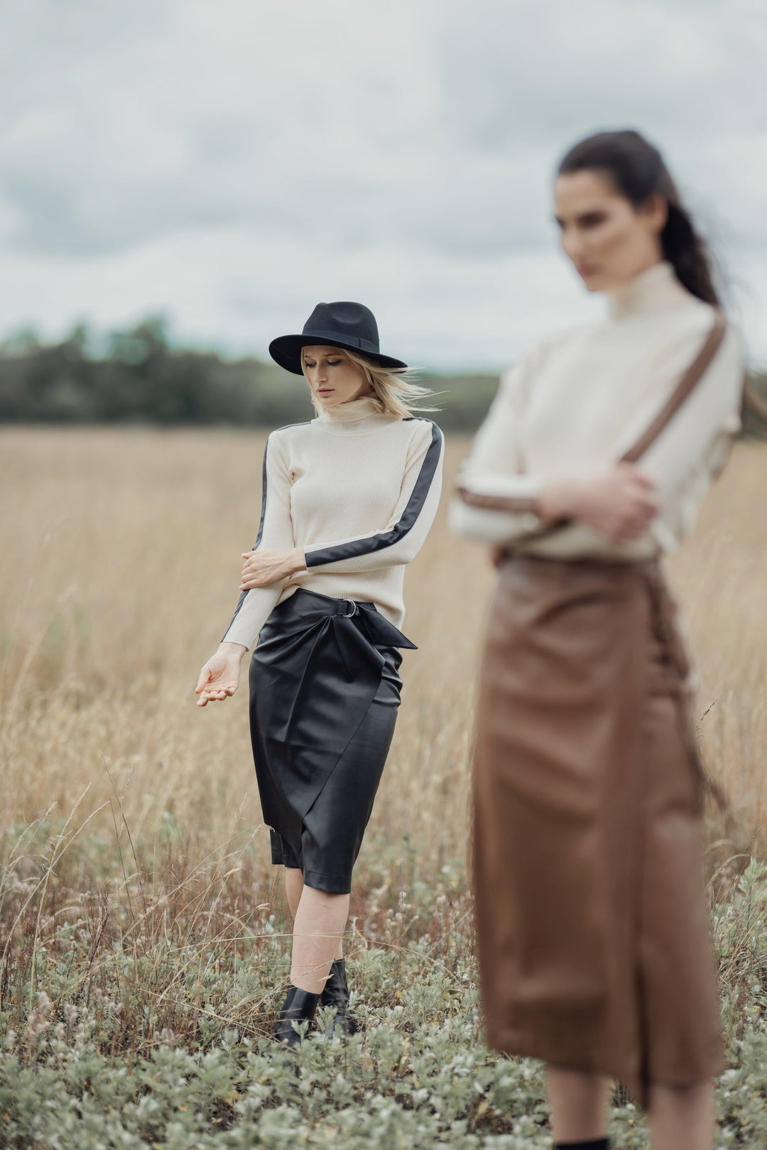 Ivory turtleneck sweater with dark leather panel across chest