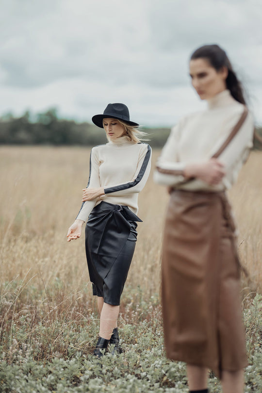 Ivory turtleneck sweater with dark leather panel across chest
