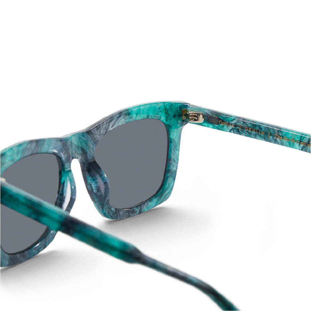 Devlin sunglasses close-up: teal mottled frame with dark lenses and metal hinge