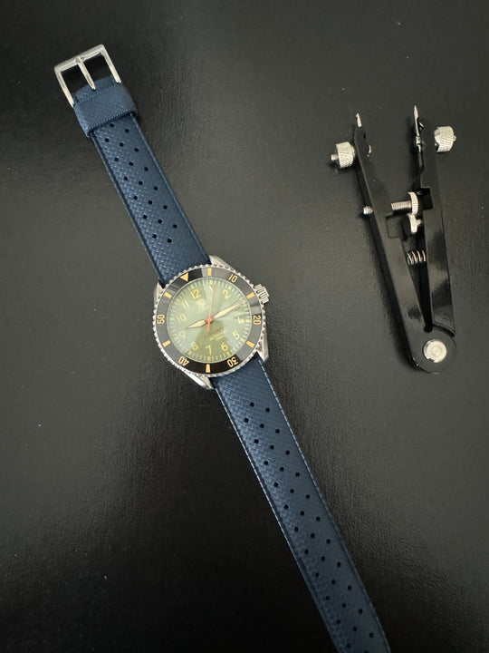 Tropic Bands watch with navy blue perforated strap and silver buckle, greenish dial