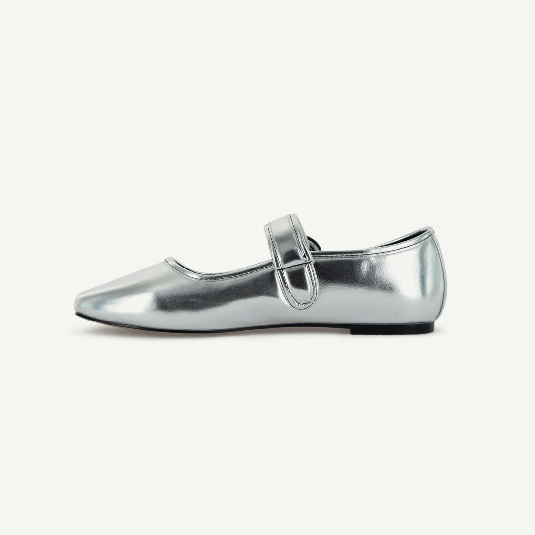 Silver Mary Jane flat side view with buckle strap and low black sole