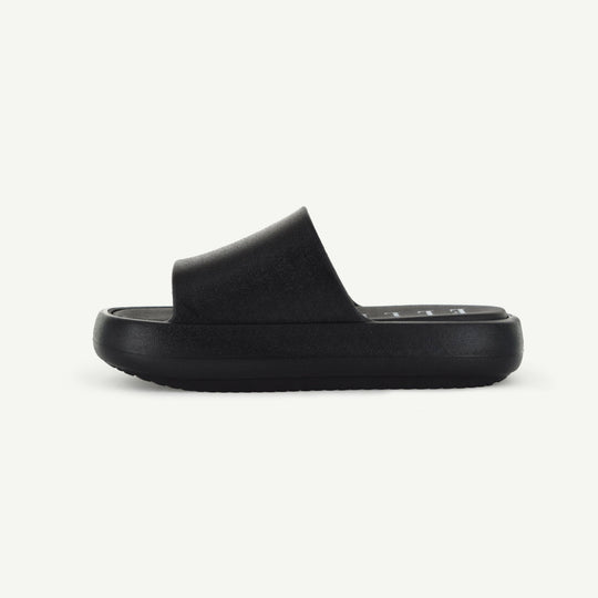 Black slide sandal, side view with thick platform sole.