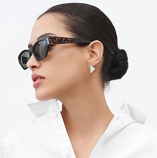 Pendiente triangular de oro con pavé de pedrería, en la oreja