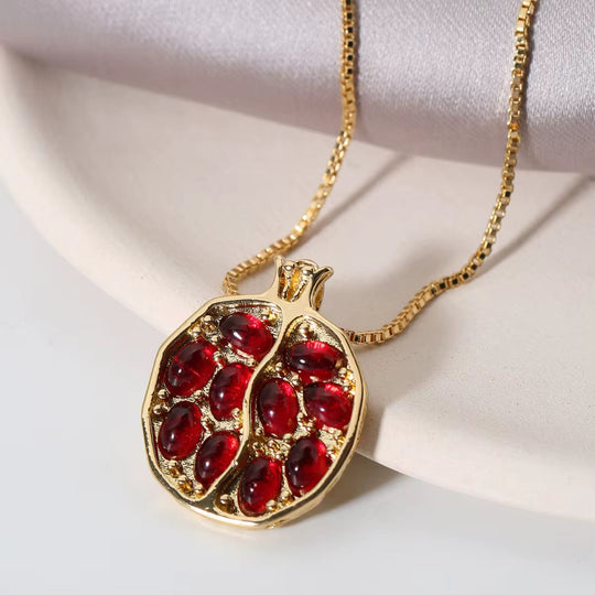Pomegranate-shaped pendant necklace with red gemstone cluster and gold-tone chain