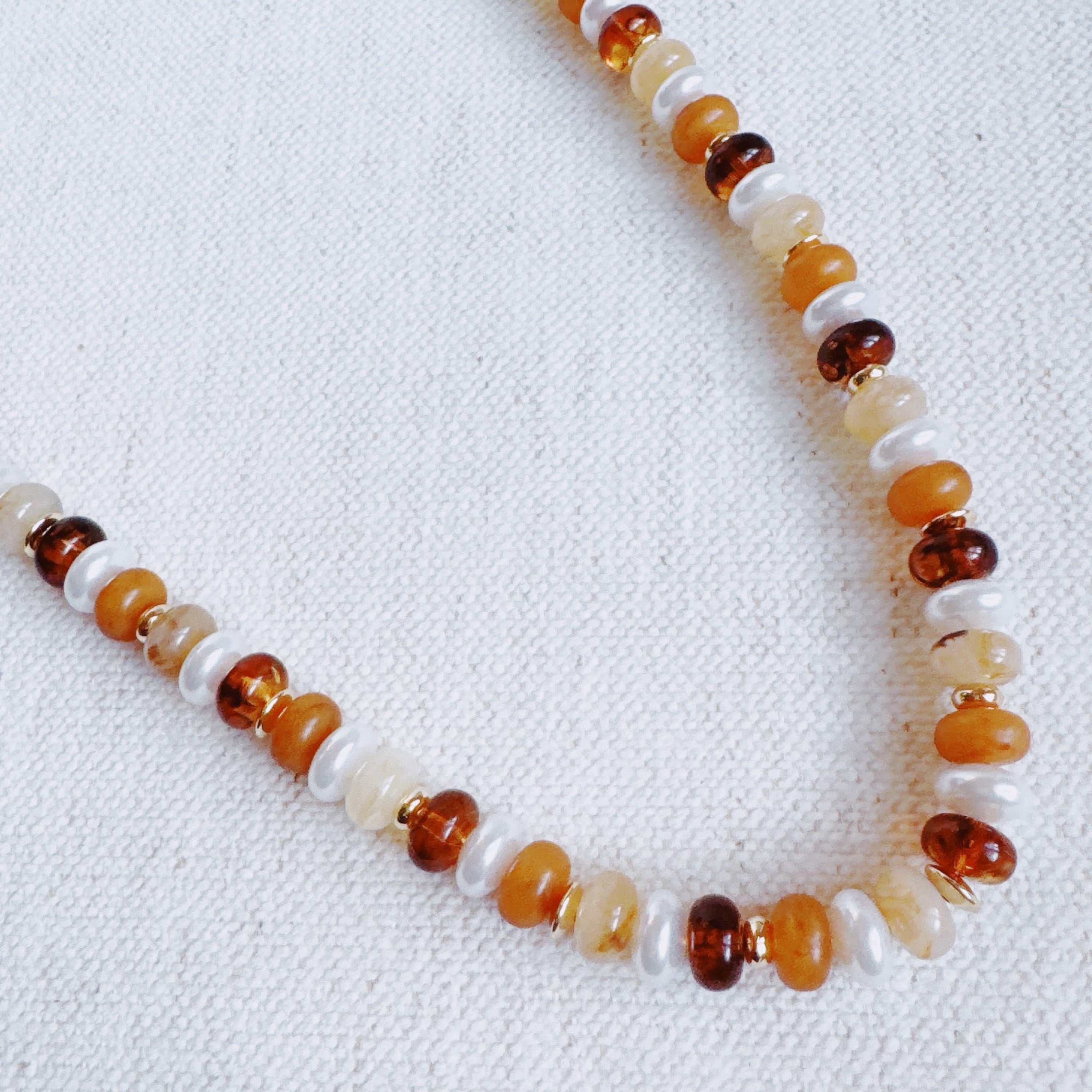 Golden Earth beaded necklace with warm orange, amber, and white stones, round beads