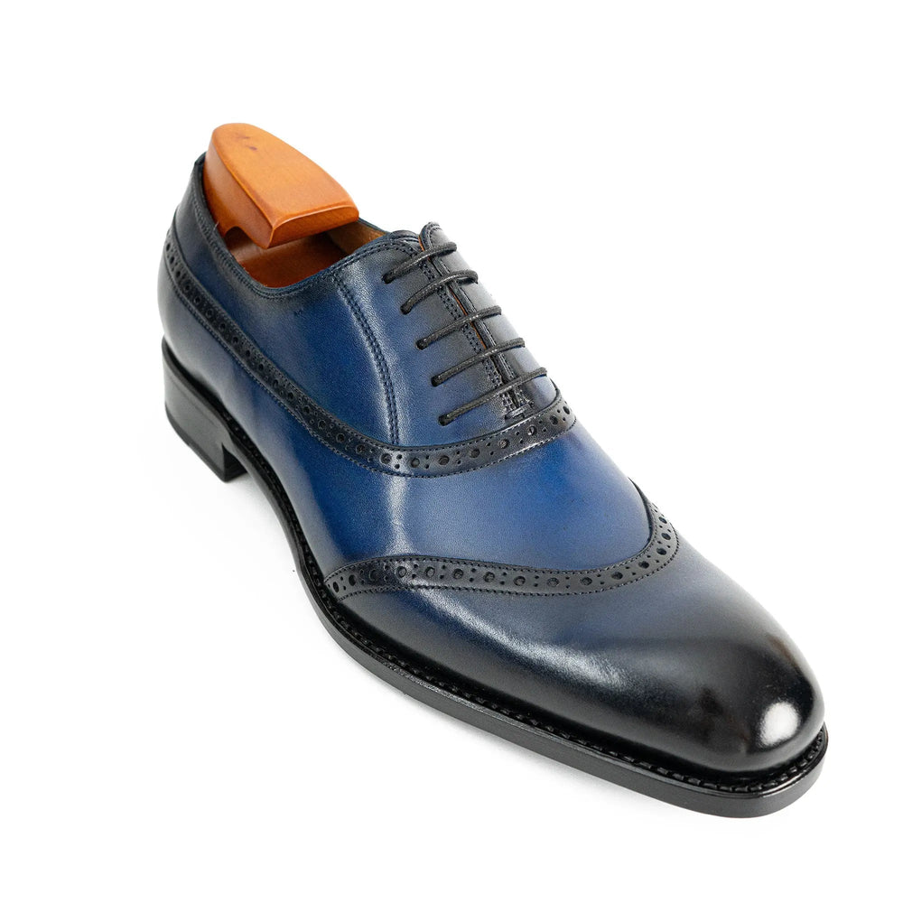 Blue oxford dress shoes with lace-up closure and perforated brogue wingtip