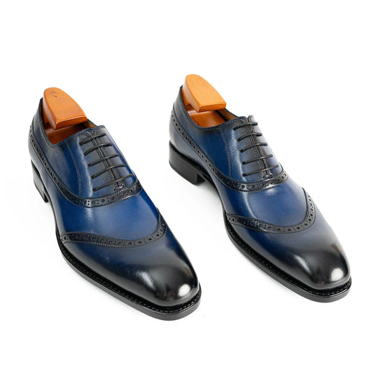 Blue oxford dress shoes pair, lace-up front with perforated wingtip brogue
