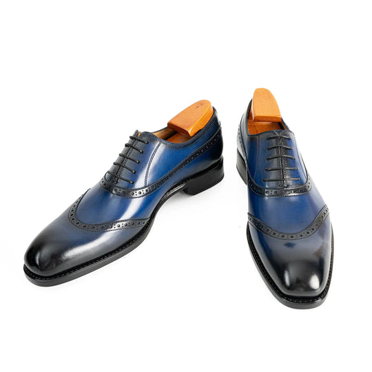 Blue oxford dress shoes side view, lace-up with perforated brogue stitching