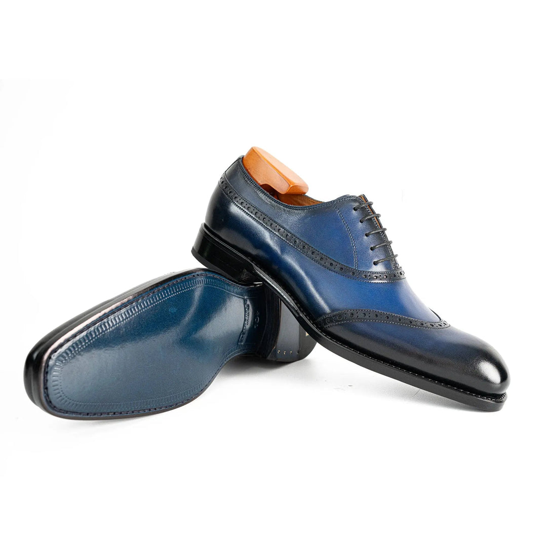 Blue oxford dress shoes, lace-up style with polished toe and brogue perforations